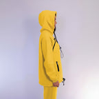 Person wearing a yellow hoodie with black accents on a light purple background