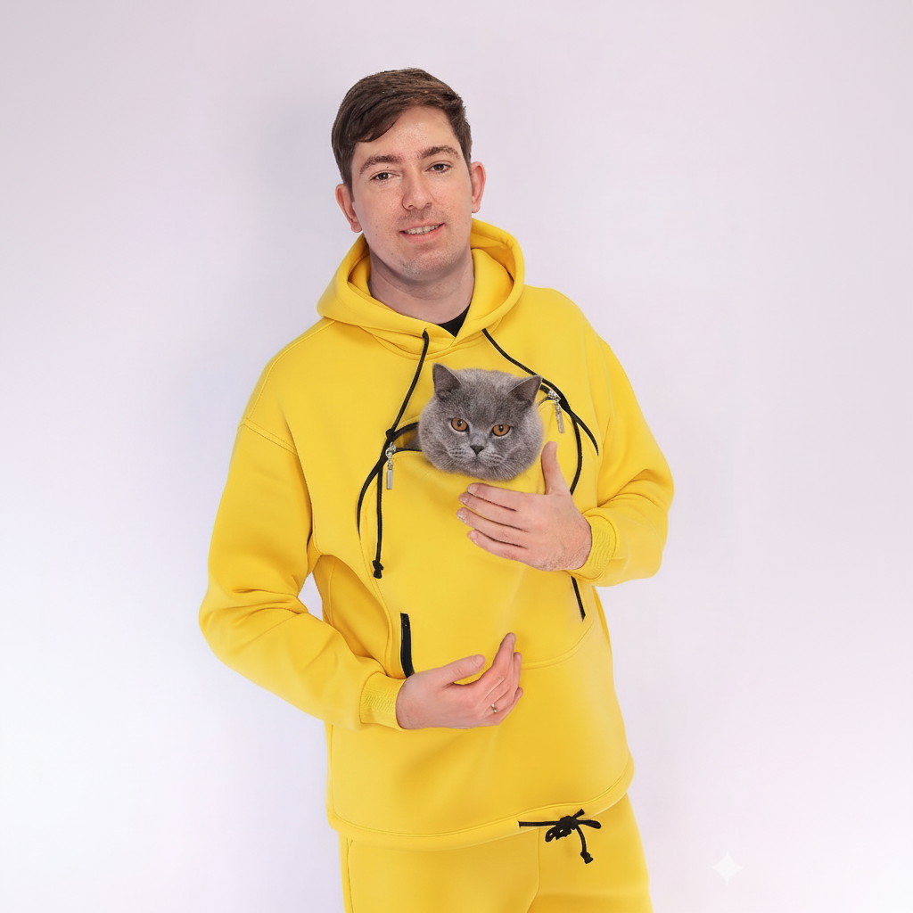 Person wearing a yellow hoodie with a cat peeking out of the front pocket against a white background