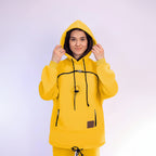Person wearing a yellow hoodie with a plain background